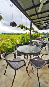 a group of tables and chairs on a patio at Paddy Villea with 5 Bedrooms Penang in Permatang Pauh