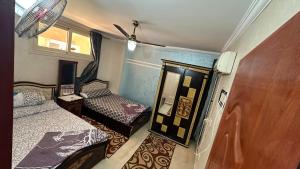 a small room with two beds and a mirror at 3 Bedroom Chalet at Dimora Village North Coast Egy - الساحل الشمالي - قرية ديمورا - شاليه 3 غرف in Dawwār Muḩammad Abū Shunaynah +18 photos