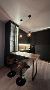 a kitchen with a wooden table and two chairs at NEXPO Apartment Бизнес-класс in Astana