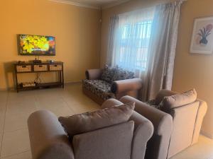 a living room with two couches and a tv at Casa Palm and Tide self catering accommodation in Swakopmund