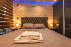 a bedroom with a bed with a blanket and two lamps at Ryo Golden Imperial 1 in Kruševac