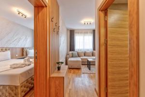 a bedroom with a bed and a living room at Boréa Apartments in Zlatibor +25 photos