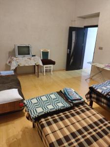 ein Zimmer mit mehreren Betten auf einem Holzboden in der Unterkunft Частный дом in Şəki