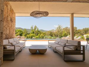 a living room with couches and a table at Villa Adeona in Zonza