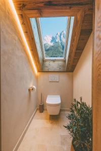 a bathroom with a toilet with a skylight at Chalet Hideaway Alpi mit Sauna und Bergblick in Grainau