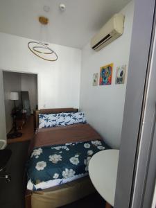 a small bedroom with a bed and a table at Aveline Suites Sunrise 2bedroom in Manila +31 photos