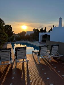 eine Gruppe von Gartenstühlen neben einem Pool in der Unterkunft Villa de los Osos - HUGE 35 PERCENT OFF NOVEMBER SPECIAL - 3min Walk To The Beach & Club De Golf Playa Serena, Entire House, Chalet With XXL Private Pool & Gym in Roquetas de Mar