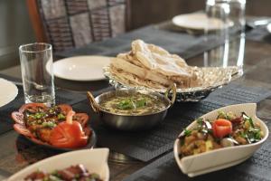 a table topped with bowls of food and bread at Winners Hill Resorts in Coimbatore