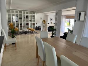 ein Esszimmer und ein Wohnzimmer mit einem Holztisch und Stühlen in der Unterkunft Villa de los Osos - HUGE 35 PERCENT OFF NOVEMBER SPECIAL - 3min Walk To The Beach & Club De Golf Playa Serena, Entire House, Chalet With XXL Private Pool & Gym in Roquetas de Mar