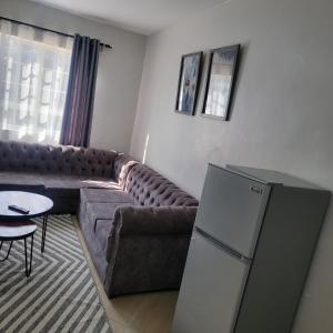 a living room with a couch and a refrigerator at Studio city in Naivasha +2 photos
