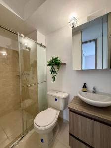 Un baño con inodoro, lavabo y ducha. en Alojamiento Moderno con Parking privado y Ubicación Privilegiada, en Armenia 9 fotos más