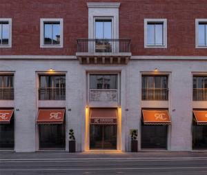Un edificio de ladrillo rojo con toldos naranjas. en Radisson Collection Hotel, Roma Antica, en Roma