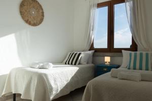 Un dormitorio con dos camas y una ventana. en La Siesta Tanca Piras, en Nebida 55 fotos más