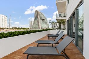 a balcony with chairs and tables and a building at 2 BR Apartment in Marina Condo in Cancún