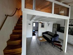 a living room with a couch and a staircase at Kaza Lenah villa 2 chambres dont une en mezzanine, piscine et cuve tampon, Saint-François in Saint-François