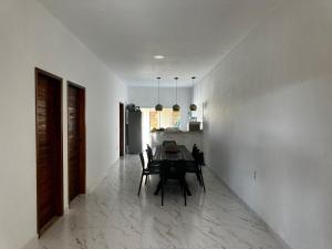 a dining room with a table and a kitchen at Casa praia beach place in Luis Correia