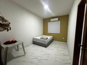 a room with a bed and a table in it at Casa praia beach place in Luis Correia