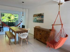 a living room with a table and a hammock at 400m da Praia | Roupa de cama/banho in Pauba