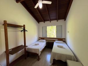 a room with two beds and a window at 400m da Praia | Roupa de cama/banho in Pauba +46 photos