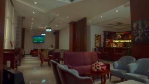 a waiting room with couches and chairs and a tv at Authopia Hotel in Addis Ababa +13 photos