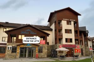 an apartment building with a sign that reads entrance from the lifts at Riders House New Gudauri in Gudauri