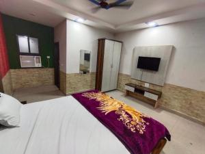 a bedroom with a bed and a flat screen tv at TRPOTELS Shree Ji in Gwalior