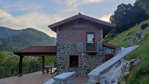 a small stone house with a balcony on a patio at EL PICO Casa en plena naturaleza con vistas espectaculares in Arredondo