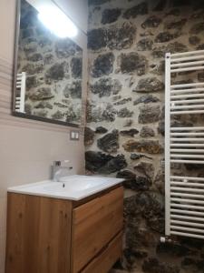 ein Badezimmer mit einem Waschbecken und einer Steinmauer in der Unterkunft EL PICO Casa en plena naturaleza con vistas espectaculares in Arredondo