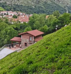 ein Haus an der Seite eines grünen Hügels in der Unterkunft EL PICO Casa en plena naturaleza con vistas espectaculares in Arredondo