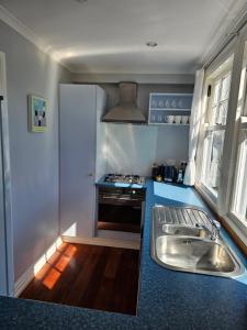 a small kitchen with a sink and a stove at Gorgeous cottage near hospital, with garage in Wellington