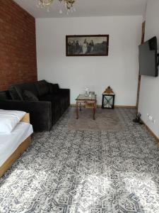 a living room with a black couch and a table at Słoneczne apartamenty Zator blisko Energylandii in Zator