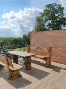 a wooden picnic table and benches on a patio at Słoneczne apartamenty Zator blisko Energylandii in Zator