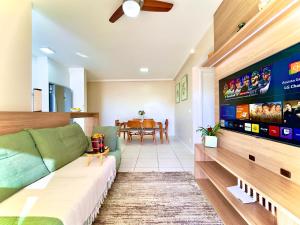 a living room with a couch and a tv at Apartamentos a150 M DA PRAIA com SACADA, WI-FI, PISCINA, PORTARIA 24h, PLAYGROUND e vaga de GARAGEM in Piçarras