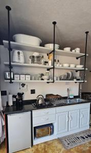 a kitchen with white shelves and a counter top at Upstairs R-3 Self Catering Unit in White River