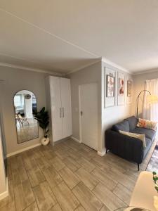 a living room with a couch and a mirror at Seabreeze Summit Retreat Your Perfect Escape in Cape Town