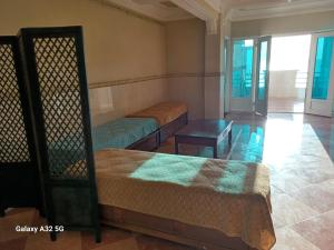 une chambre avec deux lits et une table dans l'établissement appart en front de mer, à Mostaganem