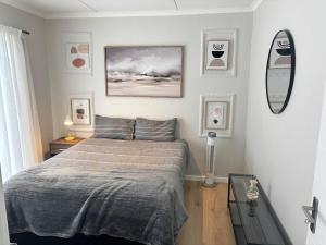 a bedroom with a bed and a mirror on the wall at Seabreeze Summit Retreat Your Perfect Escape in Cape Town