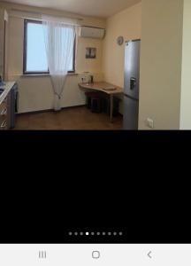 a kitchen with a refrigerator and a table and a window at Квартира in Aghk'ilisa