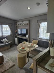 a living room with a couch and a table at Stunning 6 Berth Caravan Near To The Beach At Pakefield Ref 68115Cr in Lowestoft