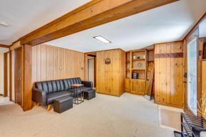 a living room with wood paneling and a leather couch and stool at Haverhill Mtn Retreat Hike, Ski, Relax in Hot Tub in Woodsville +37 photos