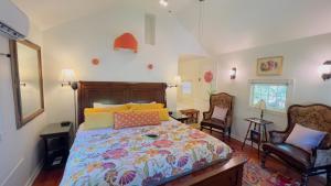 a bedroom with a bed and two chairs at Rock Cottage Gardens B&B in Eureka Springs