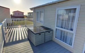 a balcony with a wicker basket on a deck at Danbury, West Sands Holiday Park in Selsey