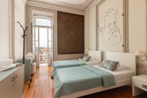 a bedroom with two beds and a window at Serenata Hotel & Hostel Coimbra in Coimbra