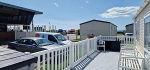 a car is parked next to a white fence at Danbury, West Sands Holiday Park in Selsey +54 photos