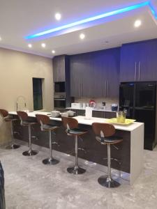 a kitchen with bar stools and a kitchen with purple cabinets at Lovemoreheights Inn in Gqeberha