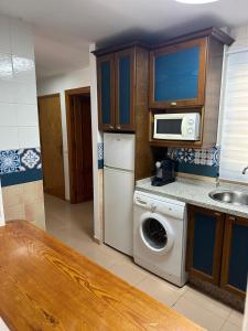 una cucina con lavatrice e microonde di Apartamento SERENITY Nerja a Nerja Altre 3 foto