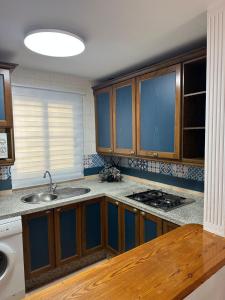 una cucina con mobili in legno e un lavello di Apartamento SERENITY Nerja a Nerja