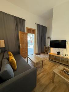 a living room with a couch and a flat screen tv at Casas La Aldea Suites Plaza in La Aldea de San Nicolas
