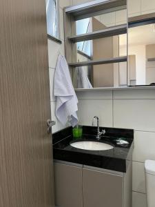 a bathroom with a sink and a mirror at Studio Completo - Local Central in João Monlevade