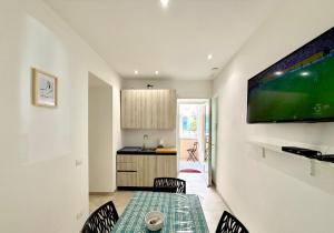a dining room with a table and a television on a wall at Scalette e Tramonti in Tropea